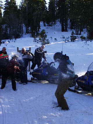 A snowfight breaks out on the mountain trail while a group of Accommodation Tahoe vacationers enjoy a snowmobile tour