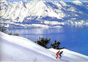 Lake Tahoe skiers enjoy the view of Lake Tahoe in the background framed by the snow covered mountains.